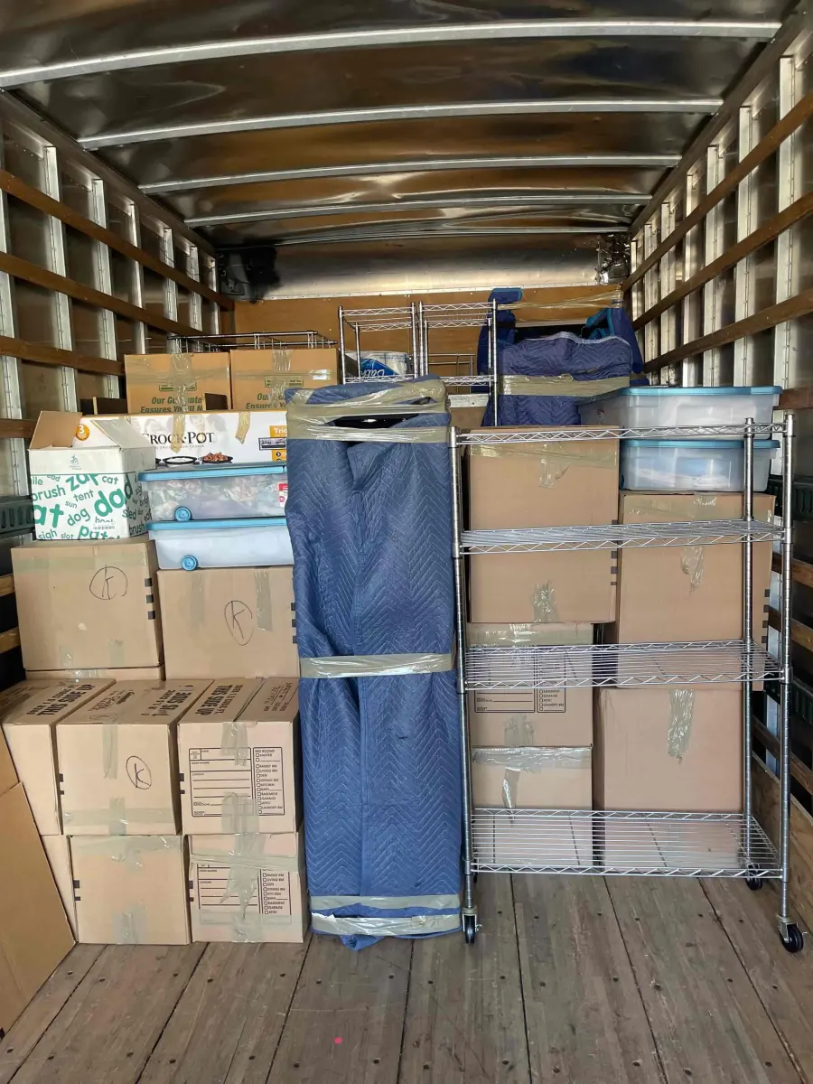 A NewView truck interior loaded floor to ceiling with padded furniture and boxes